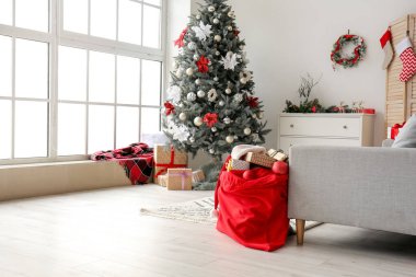 İçinde Noel ağacı ve Noel Baba çantası olan modern bir oda.