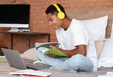 Afrikalı-Amerikalı öğrenci evde online çalışıyor.