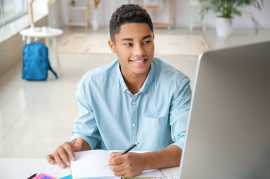 Afrikalı-Amerikalı öğrenci evde online çalışıyor.