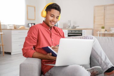 Afrikalı-Amerikalı öğrenci evde online çalışıyor.