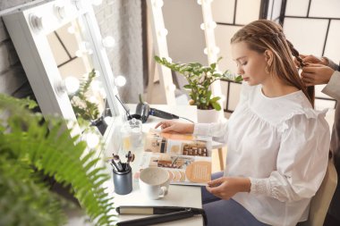 Kuaför müşteriyle güzellik salonunda çalışıyor.