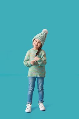 Kış giysileri içinde şık küçük kız, renkli arka plan.