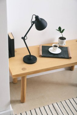 Modern lamba ve bir fincan kahve odanın ışık duvarının yanındaki masada.