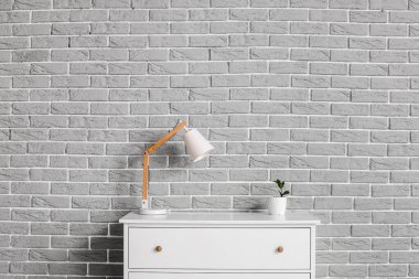 İçinde lamba ve ev bitkisi olan çekmeceler.