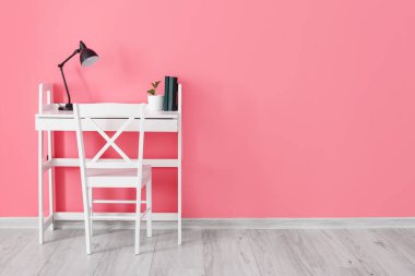 Renkli duvarın yanında lamba olan modern işyeri