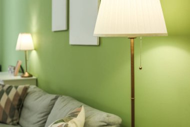 Renk duvarının yanında kanepesi olan parlak bir lamba.