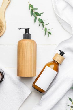 Hafif arka planda doğal şampuanlı şişeler.