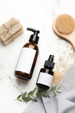 Doğal şampuan, sabun ve hafif arka planda fırça bulunan şişeler