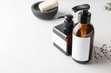 Hafif arka planda doğal şampuanlı şişeler.