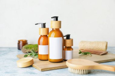 Doğal şampuanlı şişeler ve hafif arka planda fırçalar.