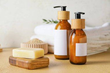 Arka planda doğal şampuan ve sabun bulunan şişeler