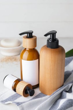 Hafif arka planda doğal şampuanlı şişeler.