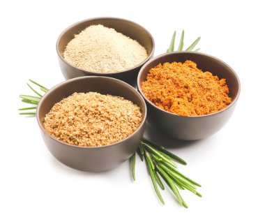 Farklı baharatlı kaseler ve beyaz arka planda biberiye.