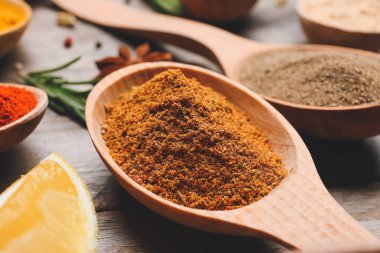 Ahşap arka planda biber tozlu kaşık, yakın plan.