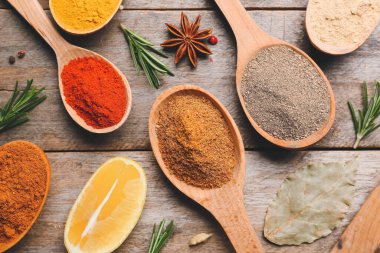 Ahşap arka planda farklı baharatlı kaşıklar.