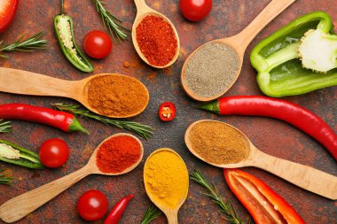 Farklı baharatlı kaşıklar ve arkaplanda farklı sebzeler.