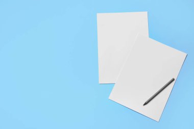 Renk arkaplanı üzerine boş kağıt ve kalem sayfaları