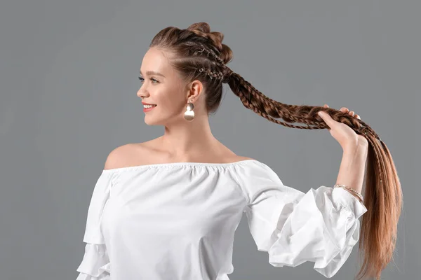 Красивая Молодая Женщина Плетеными Волосами Сером Фоне — стоковое фото