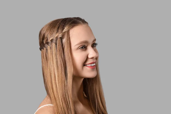 Schöne Junge Frau Mit Stilvoller Frisur Auf Grauem Hintergrund — Stockfoto