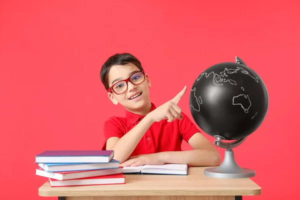 Netter Kleiner Schuljunge Mit Globus Schreibtisch Auf Farbigem Hintergrund — Stockfoto
