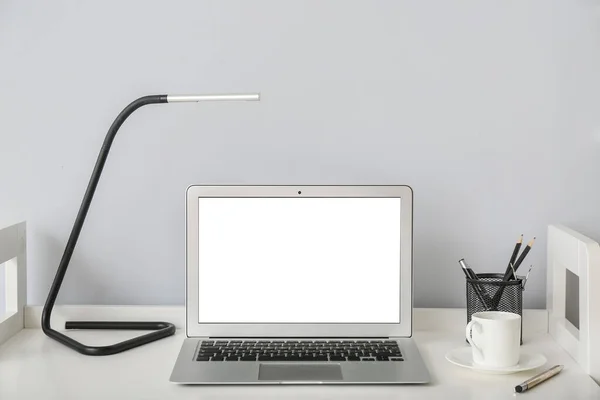 Bord Med Laptop Och Lampa Nära Ljusvägg Rummet — Stockfoto