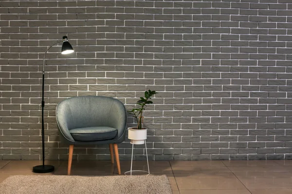 Comfortable Armchair Glowing Lamp Houseplant Brick Wall Room — Stock Photo, Image