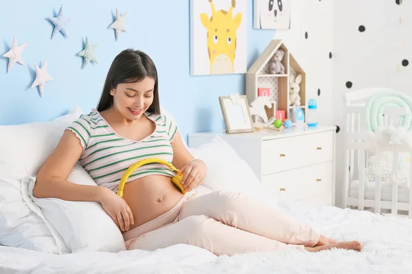 Jonge Zwangere Vrouw Zet Koptelefoon Haar Buik Thuis — Stockfoto
