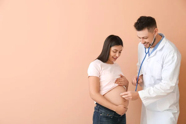 Mujer Embarazada Joven Con Médico Sobre Fondo Color — Foto de Stock