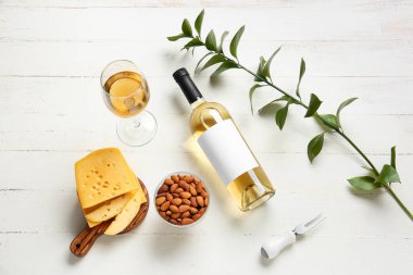 Beyaz ahşap arka planda şarap şişesi olan kompozisyon