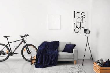 Oda içinde rahat bir kanepe ve bisiklet.