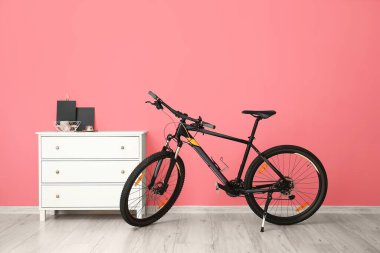 Renkli duvarın yanındaki çekmecelerin ve bisikletlerin olduğu oda.