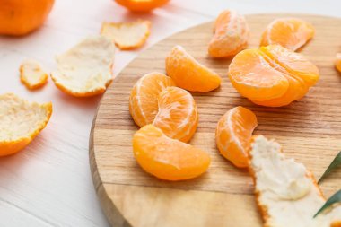 Hafif ahşap arka planda tatlı mandalinalı kompozisyon, yakın plan.