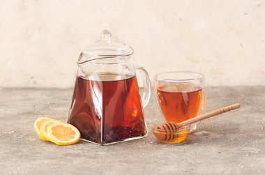 Çay, bardak, bal ve limonlu çaydanlık.