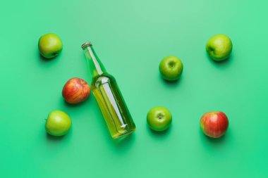 Renkli arka planda elma şarabı şişesiyle kompozisyon