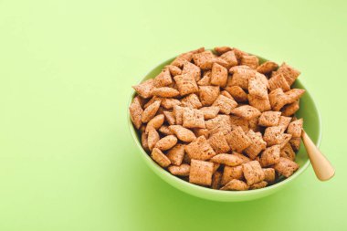 Renkli arkaplanda lezzetli mısır yastıkları olan kase