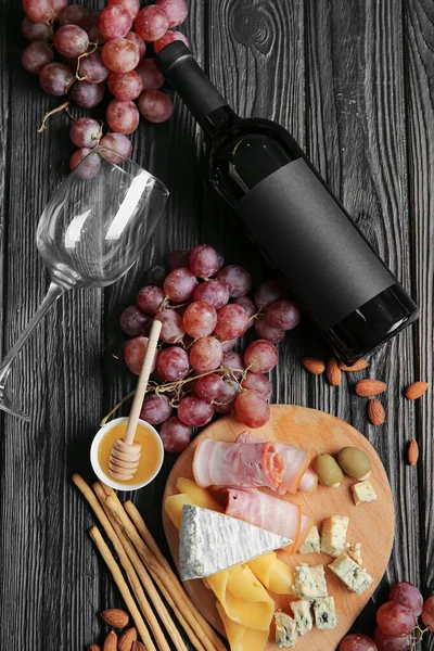 Composition with bottle of wine on dark wooden background