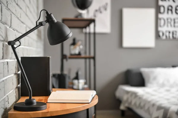 Lamp on table in interior of modern bedroom