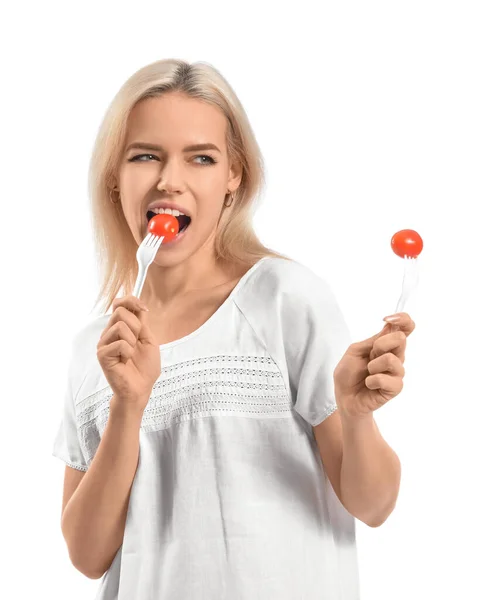 漂亮的年轻女子在白色背景下吃西红柿 — 图库照片
