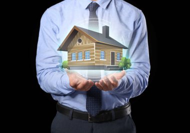 Koyu arkaplanda binanın dijital projeksiyonu olan erkek emlakçı