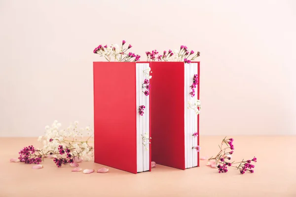 Books with fresh flowers on color background