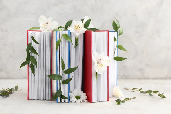 Books with floral decor on grunge background