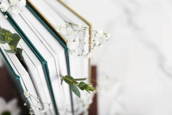Books with floral decor on white background, closeup