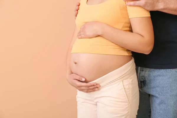 Renkli Arka Planda Güzel Hamile Bir Çift — Stok fotoğraf