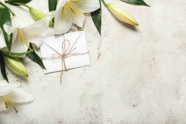 Güzel zambak çiçekleri ve açık arkaplanda bir mektup