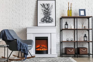 Modern oturma odasının içinde şömine ve koltuk var.