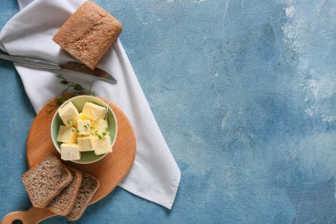 Taze tereyağlı kase ve ahşap arka planda ekmek.