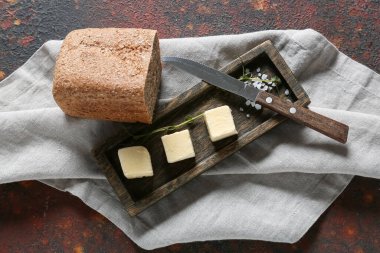 Ahşap tahta, arka planda taze tereyağı ve ekmek var.