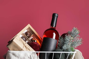 Ürünlü hediye sepeti ve renk arkaplanlı Noel dekoru