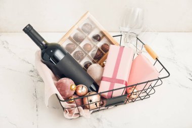 Ürünleri olan bir hediye sepeti ve ışık arka planında Noel dekoru