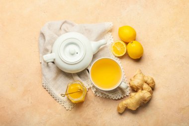 Çaydanlık ve bir fincan çay, arka planda zencefil olsun.